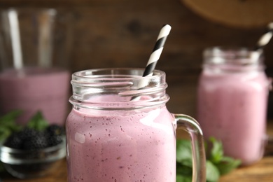 Photo of Tasty fresh milk shake with straw in mason jar, closeup