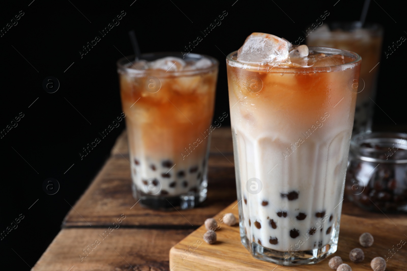 Photo of Tasty milk bubble tea on wooden table, closeup