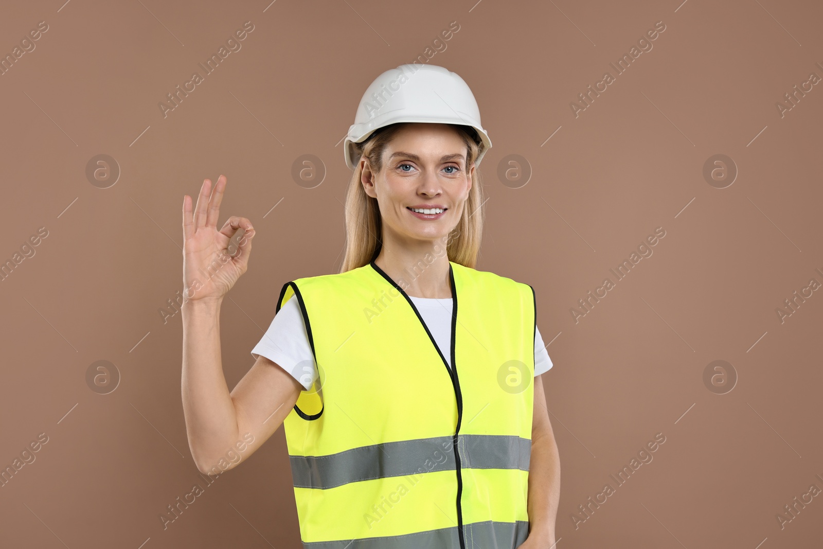 Photo of Engineer in hard hat on brown background