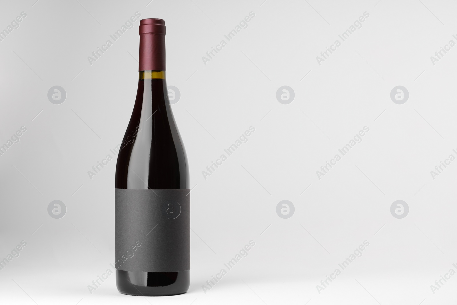 Photo of Bottle of tasty red wine on white background, space for text