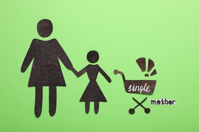Being single mother concept. Woman with her children made of paper on green background, flat lay
