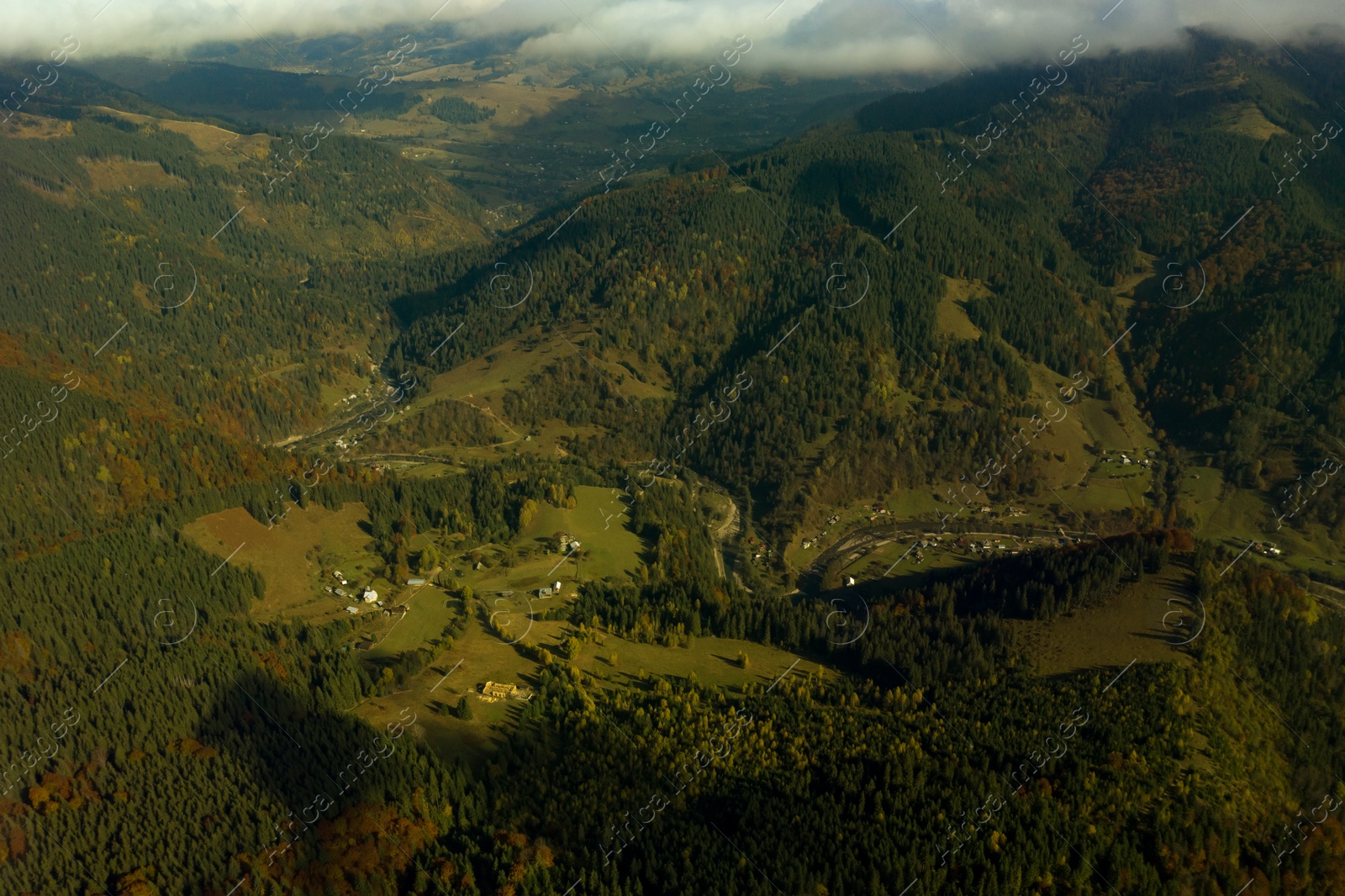 Image of Aerial view of beautiful mountain forest and village on autumn day