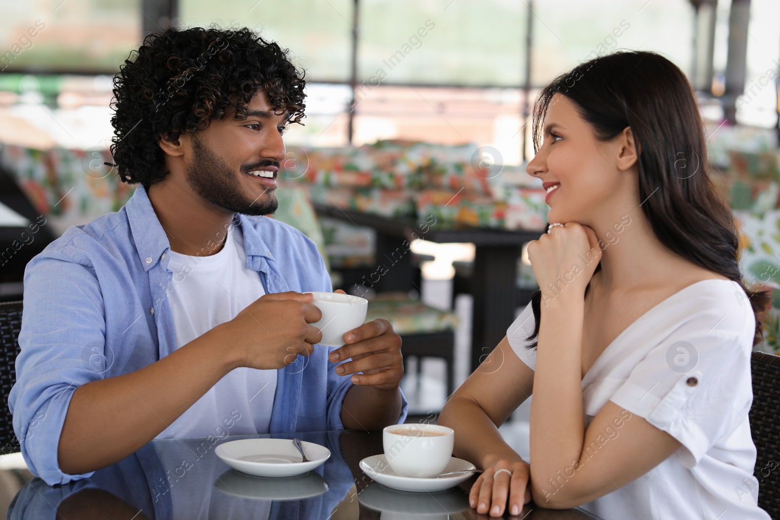 Photo of International dating. Happy couple spending time together in restaurant