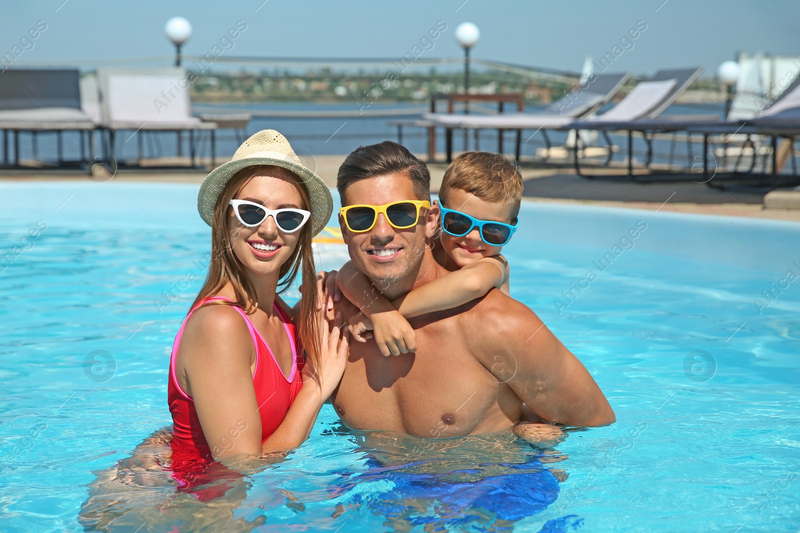 Photo of Happy family in swimming pool on sunny day