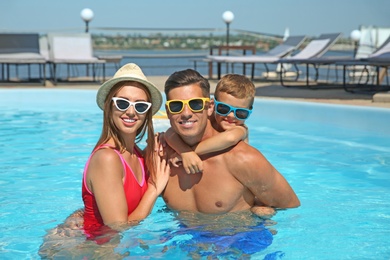 Photo of Happy family in swimming pool on sunny day