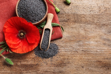 Photo of Flat lay composition with poppy seeds and flower on wooden table, space for text