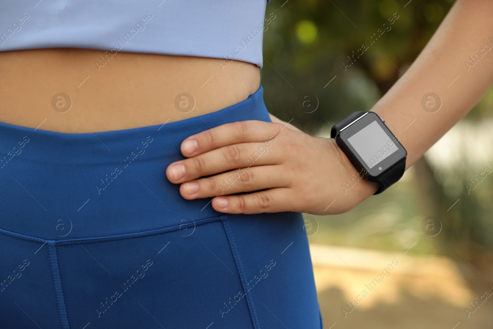 Photo of Woman with stylish smart watch outdoors, closeup