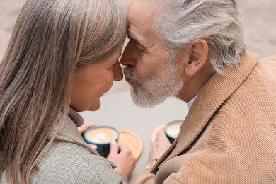 Photo of Portrait of affectionate senior couple kissing outdoors, closeup
