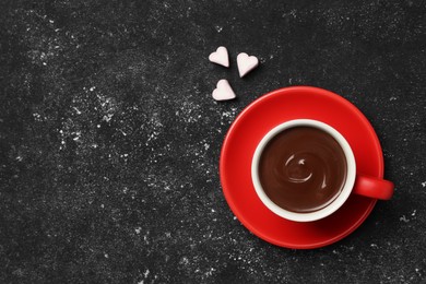 Cup of hot chocolate with heart shaped marshmallows on grey table, top view. Space for text