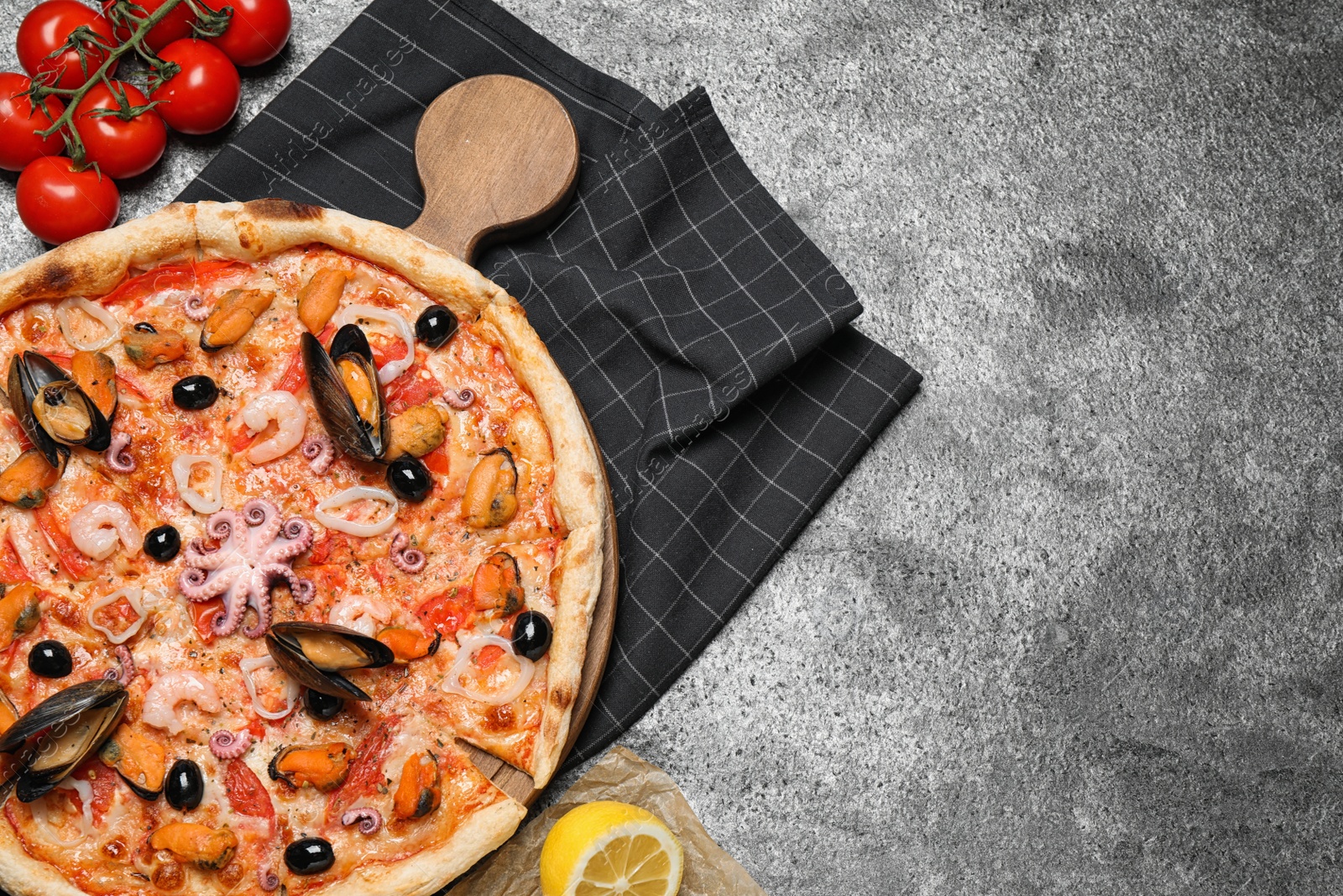 Photo of Tasty pizza with seafood and ingredients on grey table, flat lay. Space for text