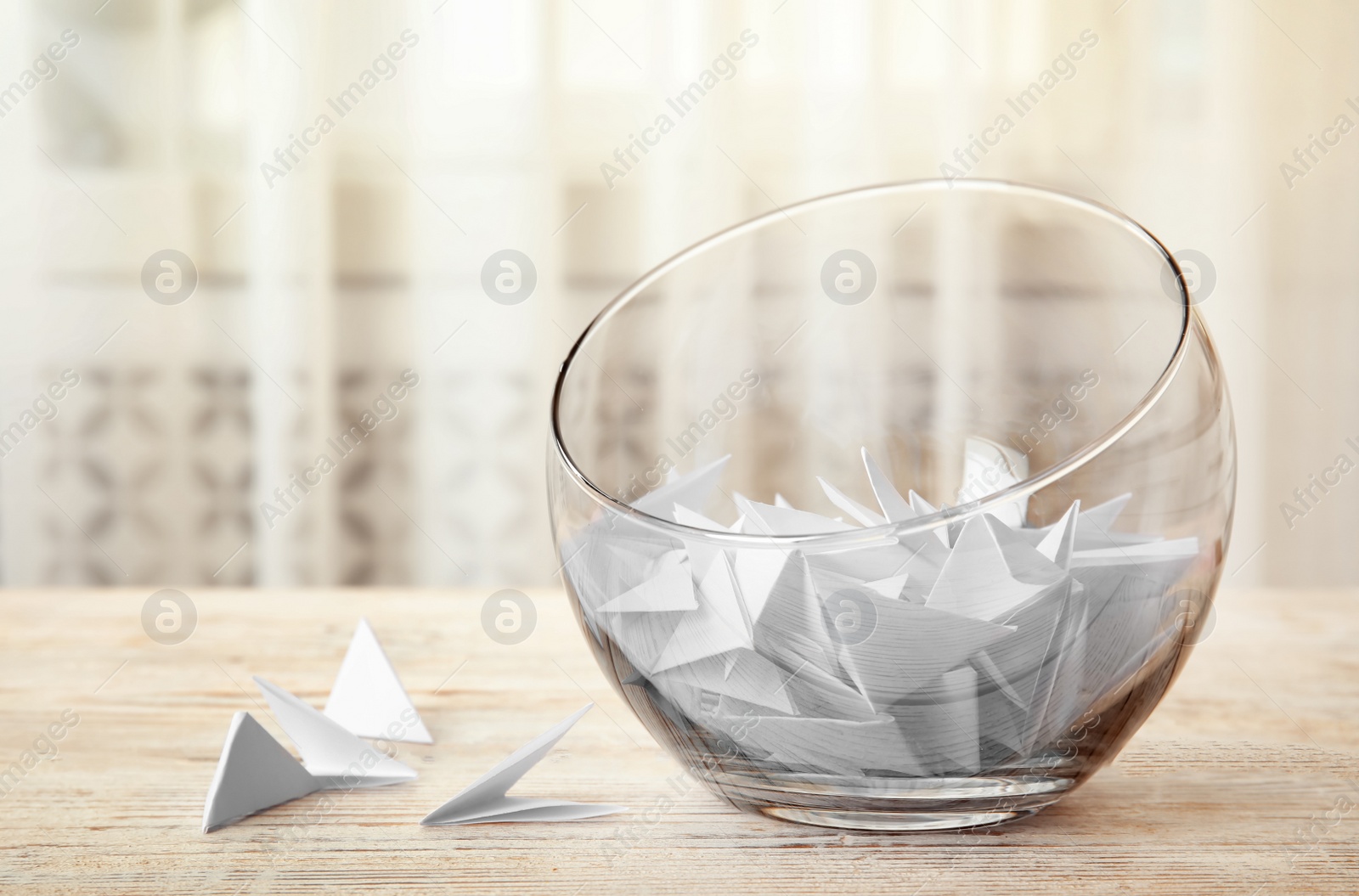 Photo of Paper pieces for lottery in glass vase on wooden table. Space for text