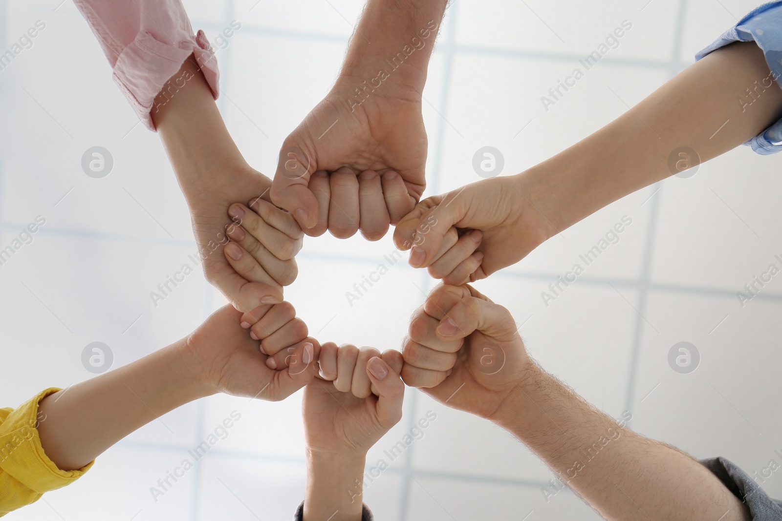 Photo of People holding fists together indoors, bottom view