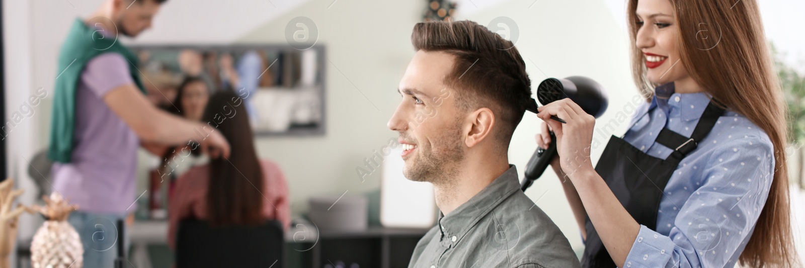 Image of Professional hairdresser working with client in beauty salon. Banner design