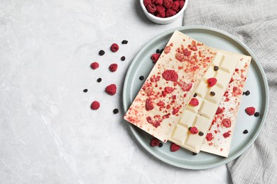 White chocolate bars with freeze dried fruits on grey marble table, flat lay. Space for text