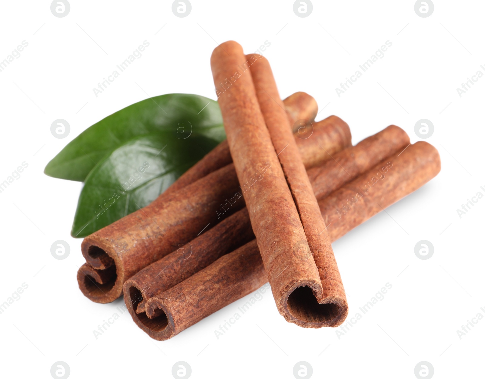 Photo of Cinnamon sticks and green leaves isolated on white