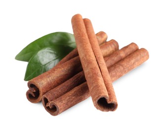 Photo of Cinnamon sticks and green leaves isolated on white