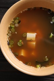 Photo of Bowl of delicious miso soup with tofu on table, top view