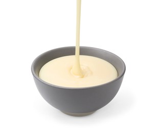 Photo of Pouring condensed milk into bowl isolated on white