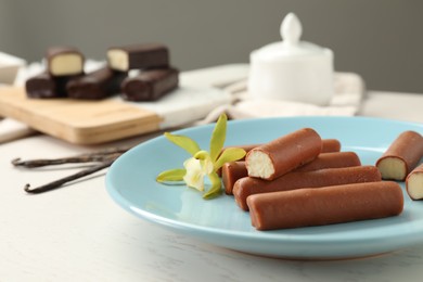 Photo of Glazed vanilla curd cheese bars served on white wooden table, closeup