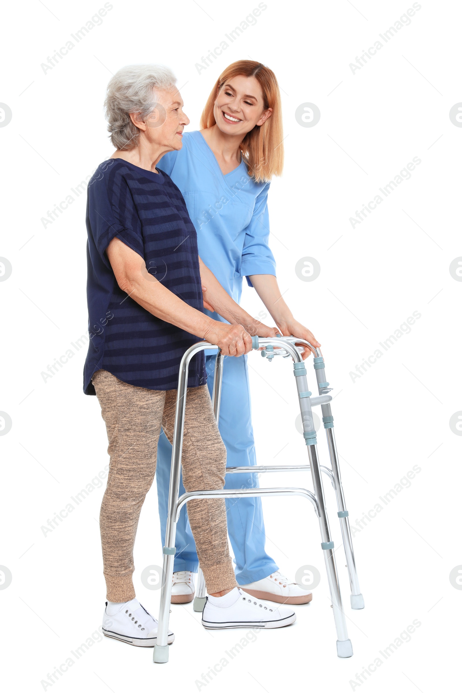 Photo of Caretaker helping elderly woman with walking frame on white background