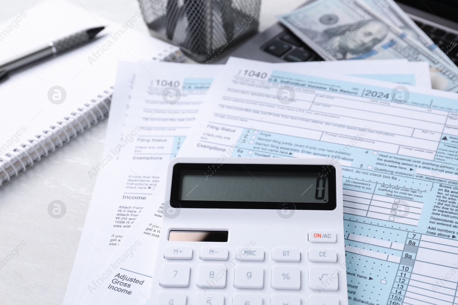 Photo of Tax accounting. Calculator, documents, money and stationery on light grey table, closeup