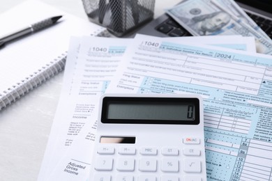 Tax accounting. Calculator, documents, money and stationery on light grey table, closeup