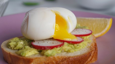 Tasty sandwich with boiled egg and radish on pink plate, closeup