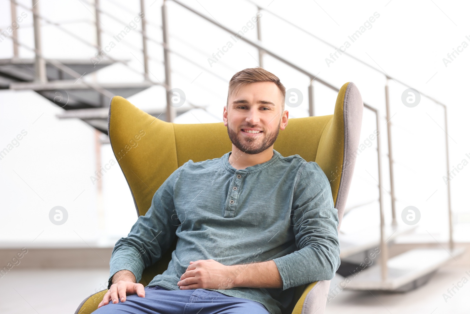 Photo of Portrait of confident young man in armchair