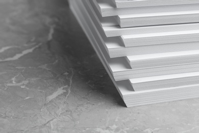 Photo of Stack of blank white paper on marble table, closeup. Space for text