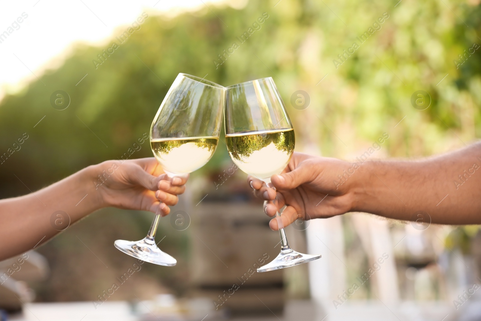 Photo of Couple with glasses of white wine outdoors, closeup