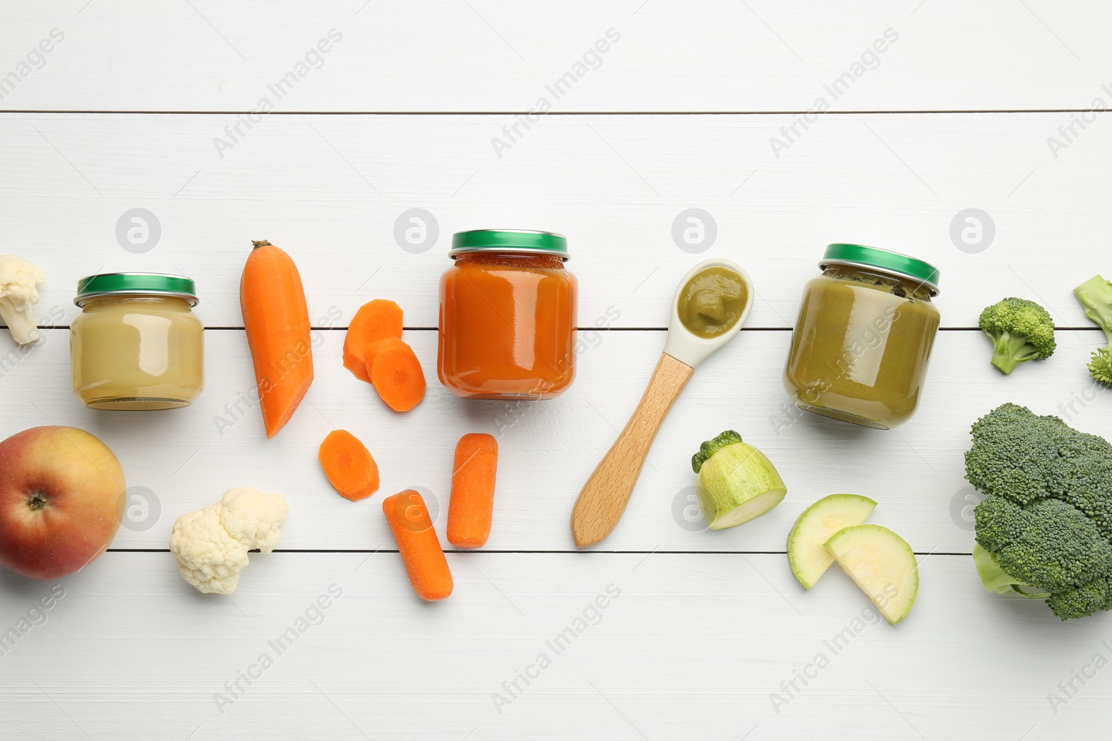 Photo of Flat lay composition with tasty baby food in jars and ingredients on white wooden table