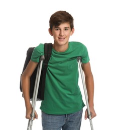 Photo of Teenage boy with injured leg using crutches on white background