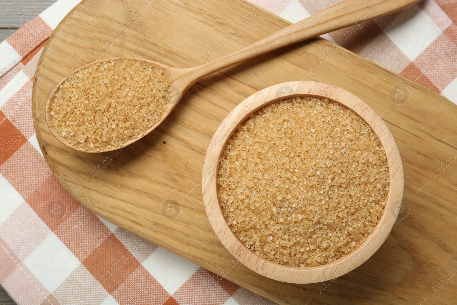 Photo of Brown sugar in bowl and spoon on table, top view