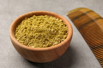 Photo of Henna powder and comb on light grey background, closeup. Natural hair coloring