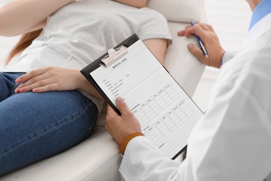 Photo of Doctor filling patient's medical card in clinic, closeup