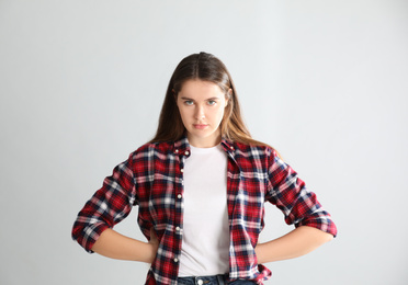 Portrait of angry young woman on light background