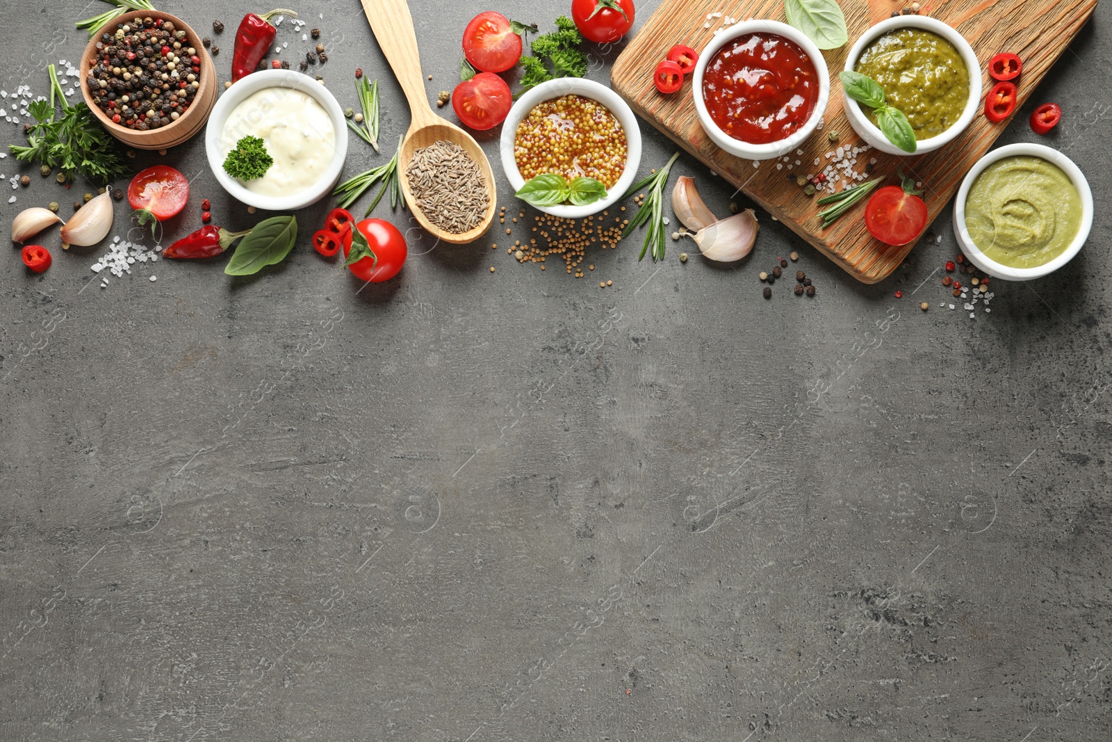 Photo of Flat lay composition with different sauces and space for text on gray background