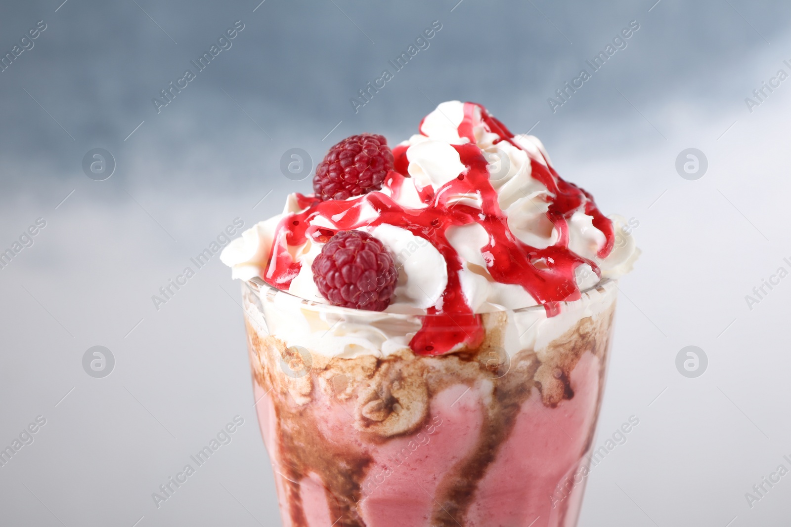 Photo of Tasty milk shake with topping on color background, closeup