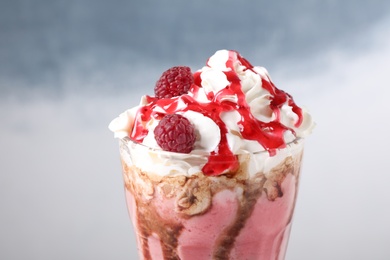 Photo of Tasty milk shake with topping on color background, closeup