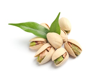 Photo of Tasty organic pistachio nuts with leaves on white background