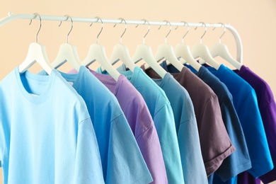 Photo of Men's clothes hanging on wardrobe rack against light background