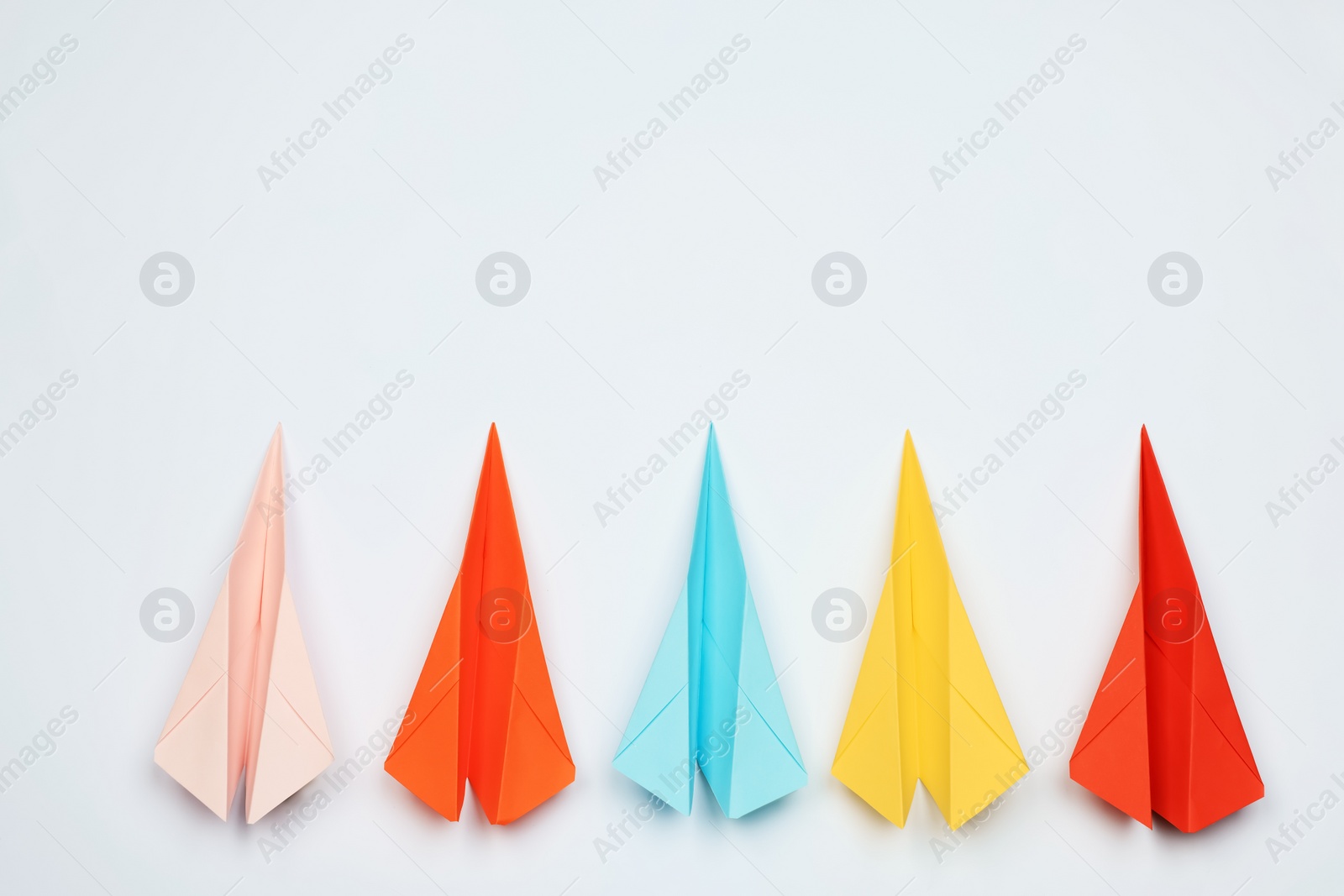 Photo of Handmade colorful paper planes on white table, flat lay. Space for text