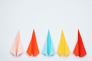 Photo of Handmade colorful paper planes on white table, flat lay. Space for text