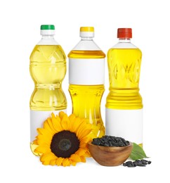 Bottles with sunflower cooking oil, seeds and yellow flower on white background