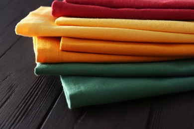Photo of Different colorful napkins on wooden table, closeup