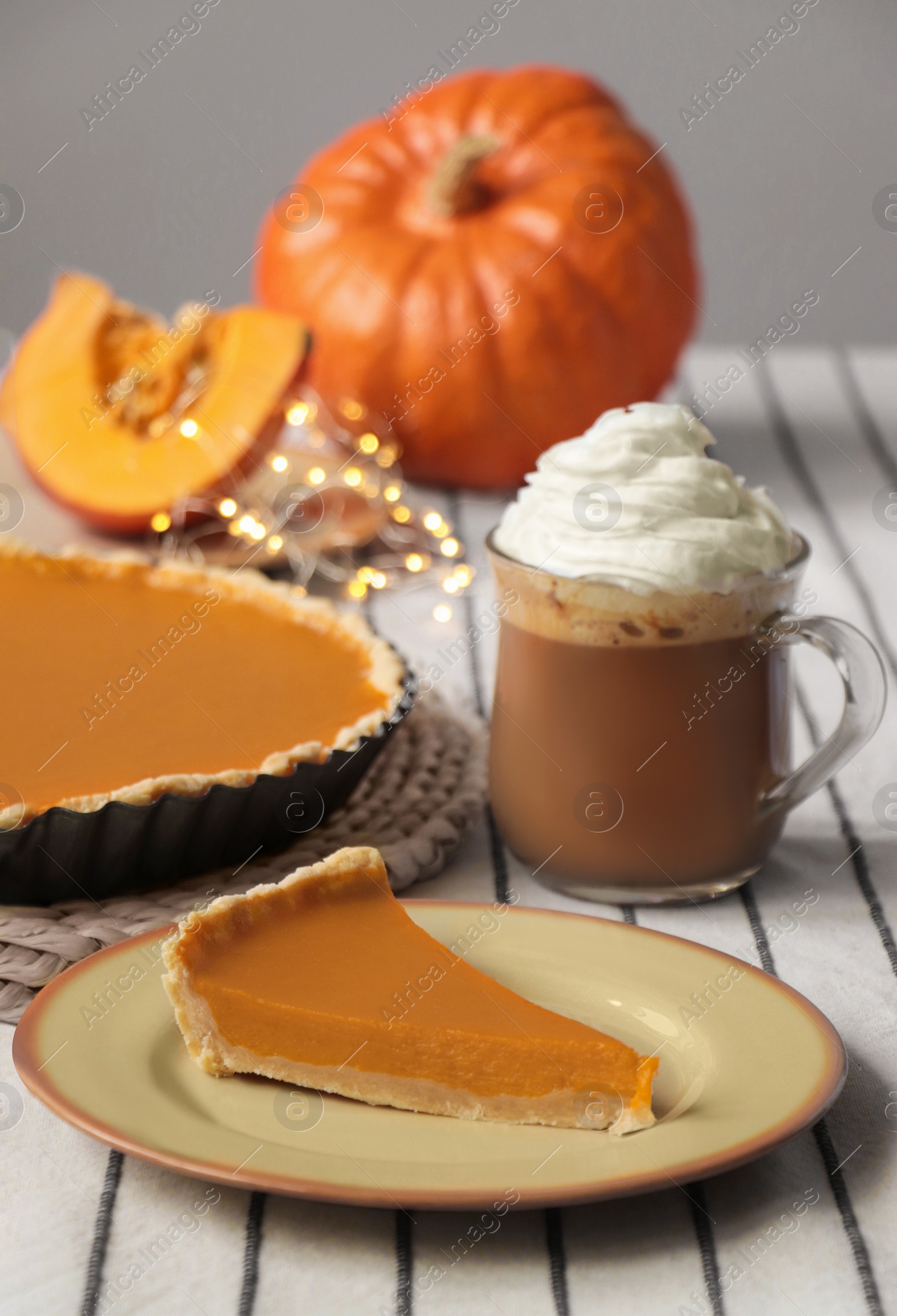 Photo of Fresh homemade pumpkin pie and cup of cocoa with whipped cream on table