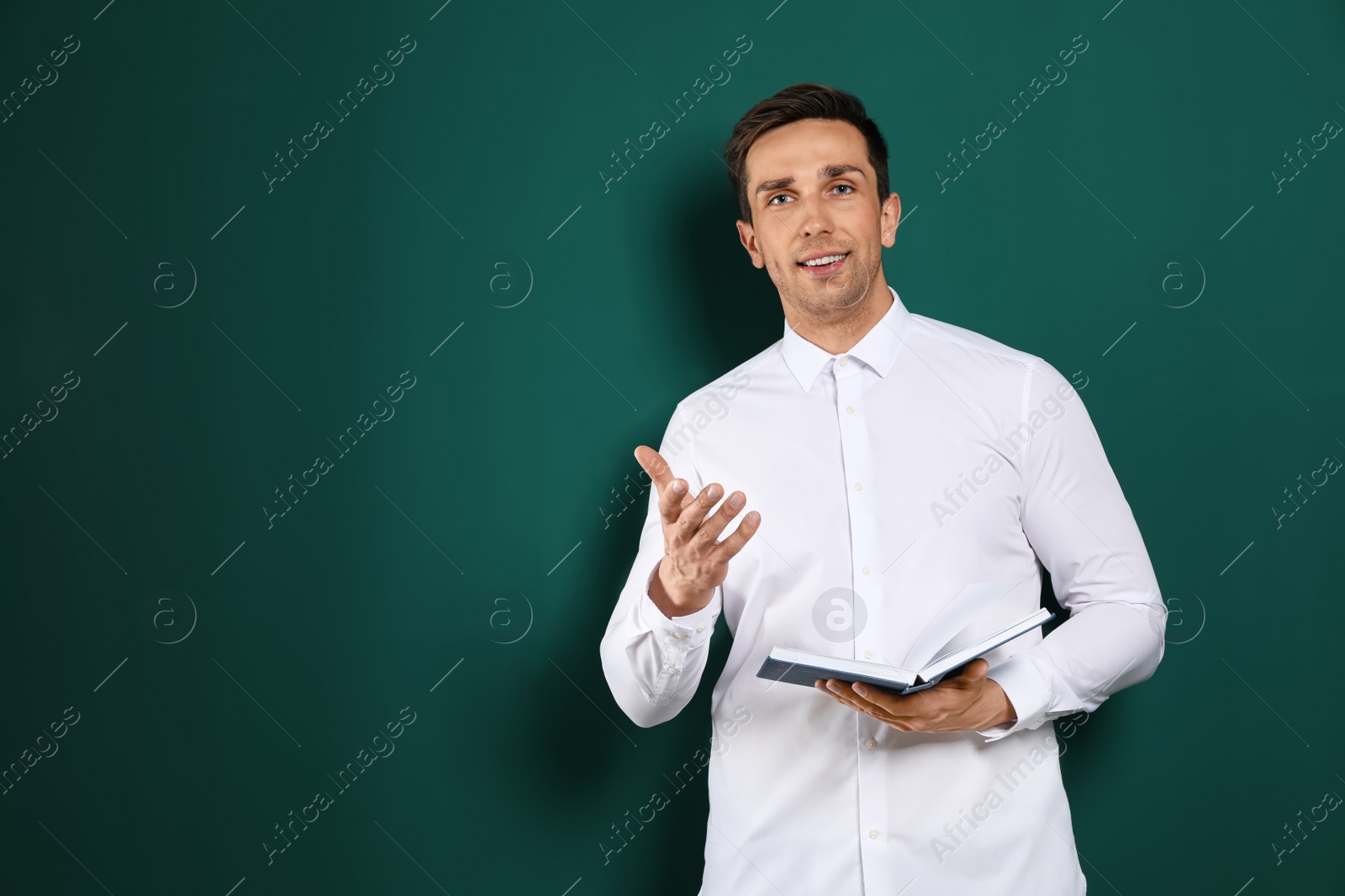 Photo of Portrait of male teacher with book on color background. Space for text