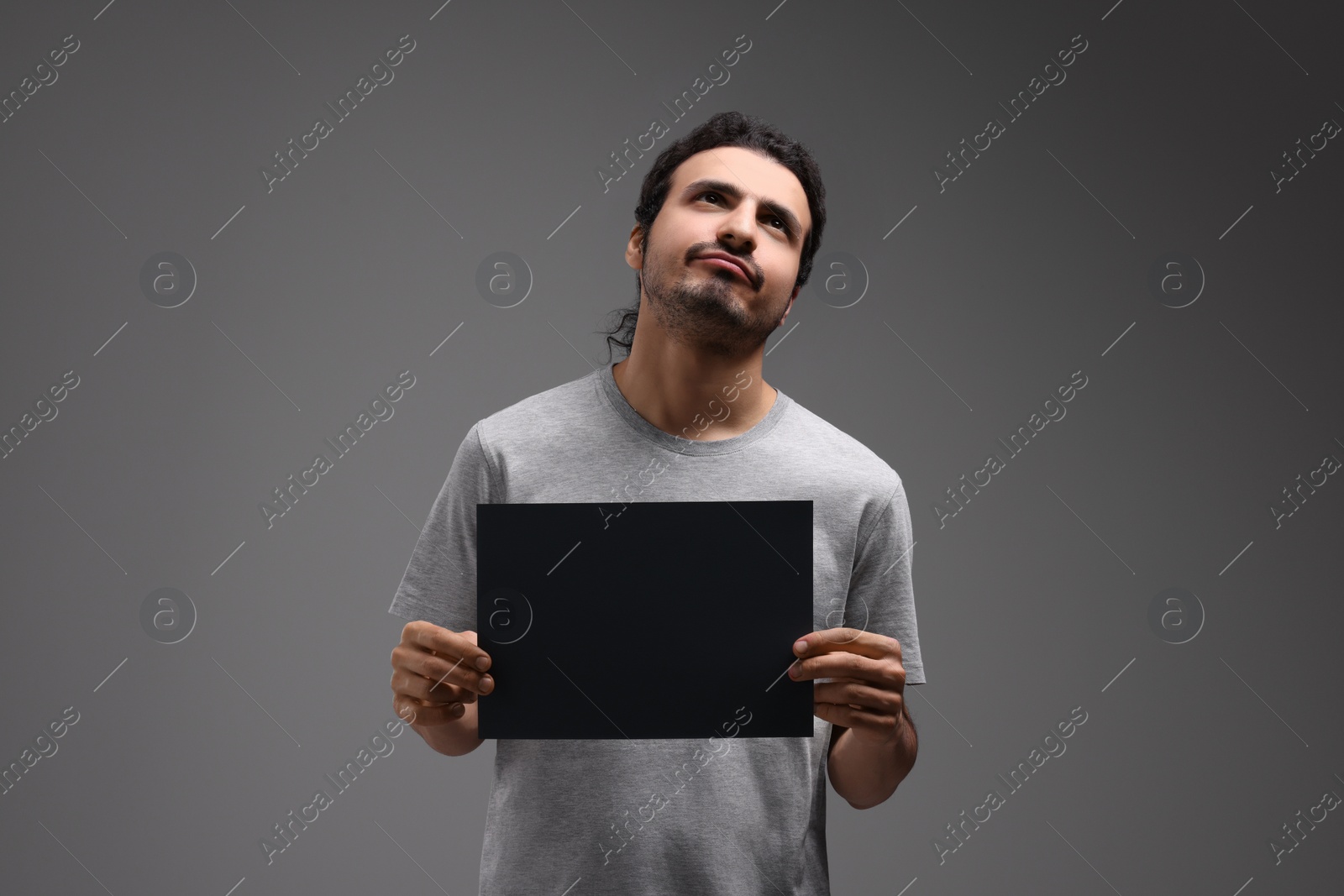 Photo of Arrested man with blank paper card on grey background