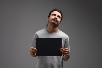 Photo of Arrested man with blank paper card on grey background