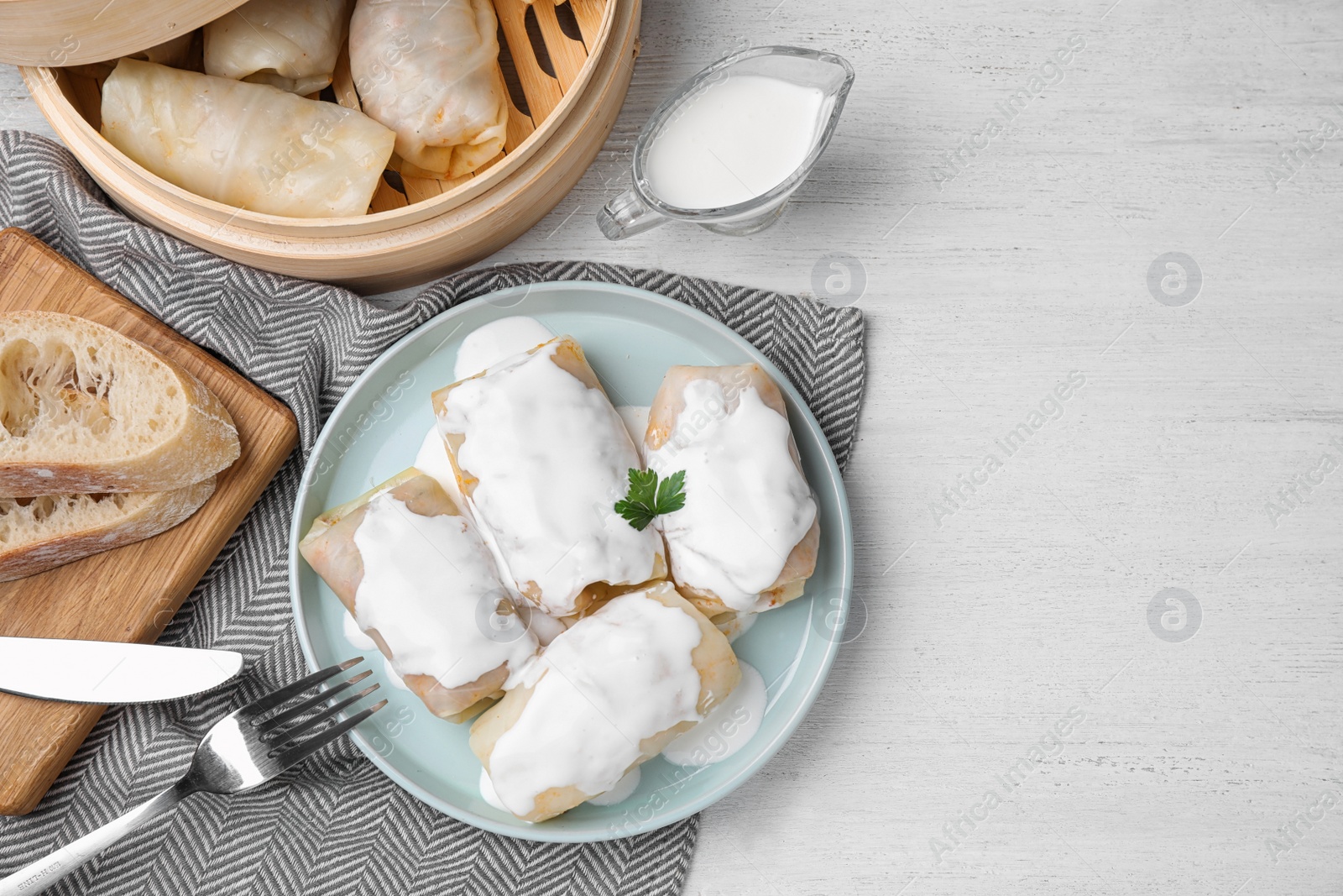 Photo of Delicious cabbage rolls served on white wooden table, flat lay